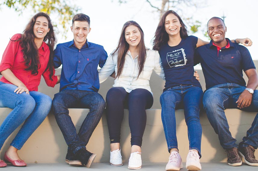 Students together smiling on campus.